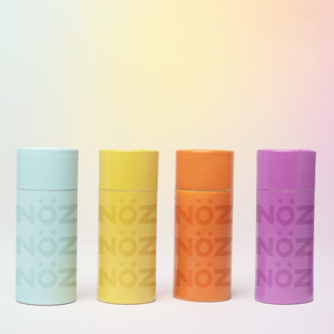 Four eco-friendly NÖZ sunscreens next to each other in colors blue, yellow, orange and purple.
